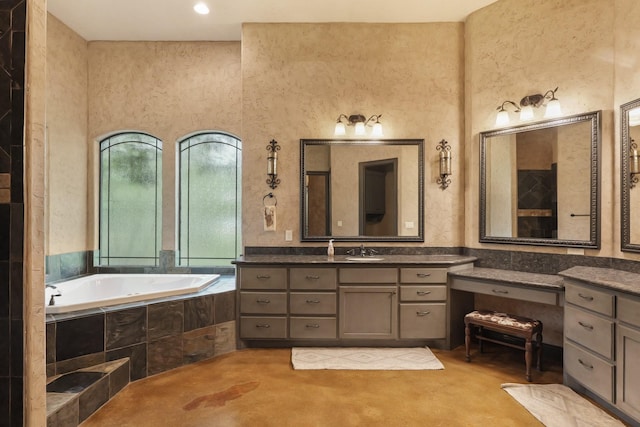 bathroom with vanity and tiled tub