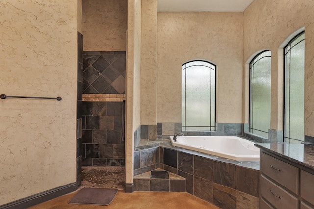 bathroom with a garden tub and tiled shower