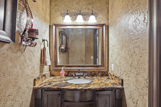 bathroom with a textured wall and vanity