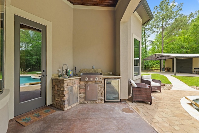 view of patio with an outdoor kitchen, a sink, and wine cooler