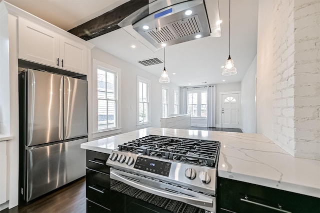 kitchen with white cabinetry, a wealth of natural light, light stone counters, and appliances with stainless steel finishes