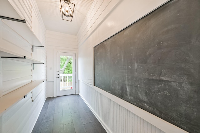 doorway to outside featuring dark wood finished floors and a notable chandelier