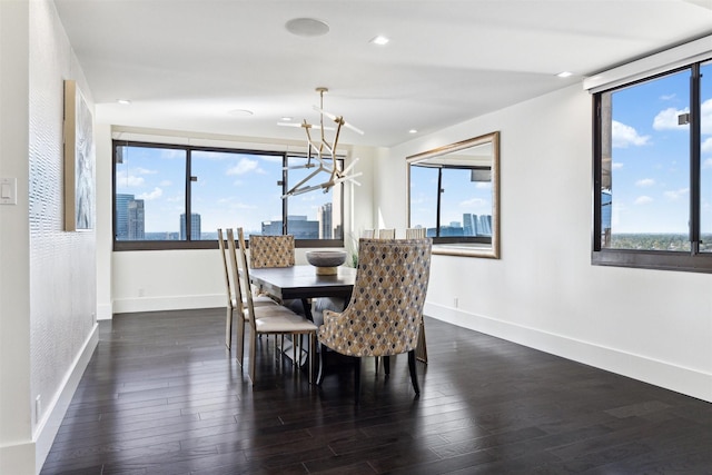 dining room with baseboards, a wealth of natural light, a notable chandelier, and wood finished floors