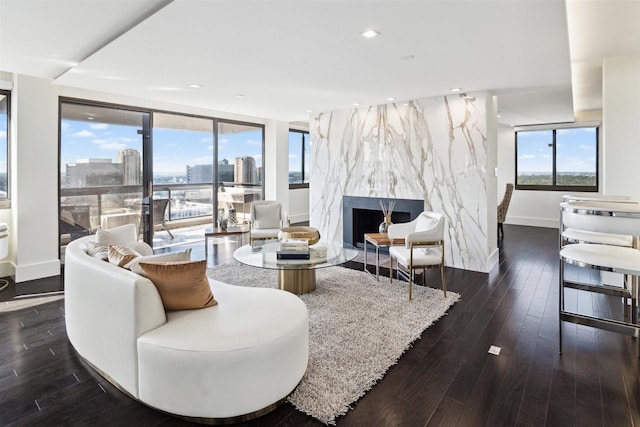 living area with dark wood-type flooring, baseboards, recessed lighting, and a premium fireplace
