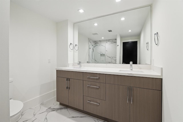 bathroom with double vanity, toilet, a marble finish shower, marble finish floor, and a sink