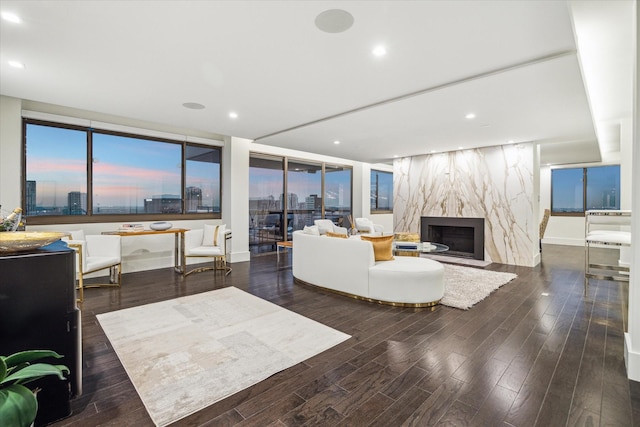 living room with recessed lighting, a premium fireplace, a view of city, and wood finished floors