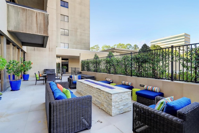 view of patio / terrace featuring an outdoor living space with a fire pit and fence