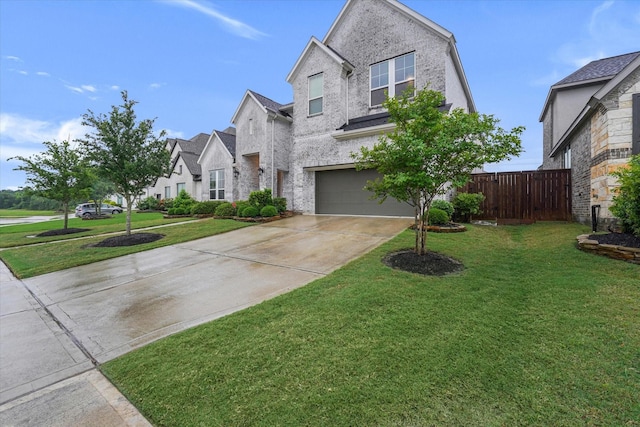 view of front facade with a front lawn, a garage, a residential view, driveway, and fence