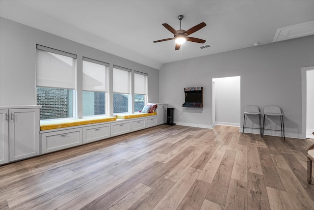 unfurnished living room featuring light wood-style floors, attic access, ceiling fan, baseboards, and visible vents