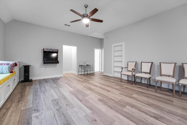 sitting room with visible vents, a ceiling fan, built in features, and light wood-style floors