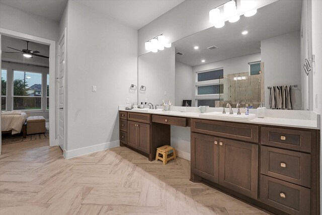 bathroom featuring baseboards, tiled shower, ceiling fan, and a sink