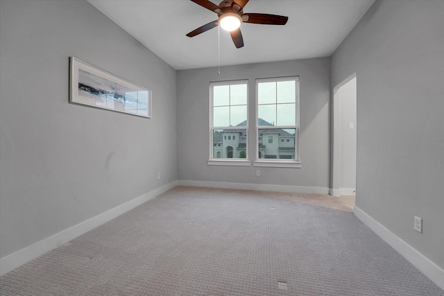 empty room with baseboards, ceiling fan, and light colored carpet