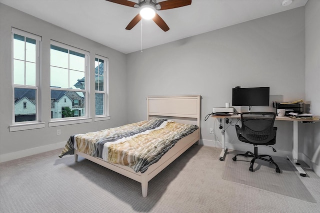carpeted bedroom with a ceiling fan and baseboards