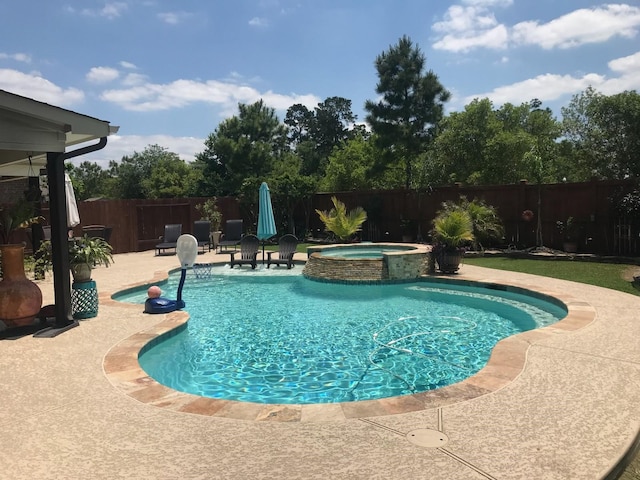 view of swimming pool with a patio, a fenced backyard, and a pool with connected hot tub
