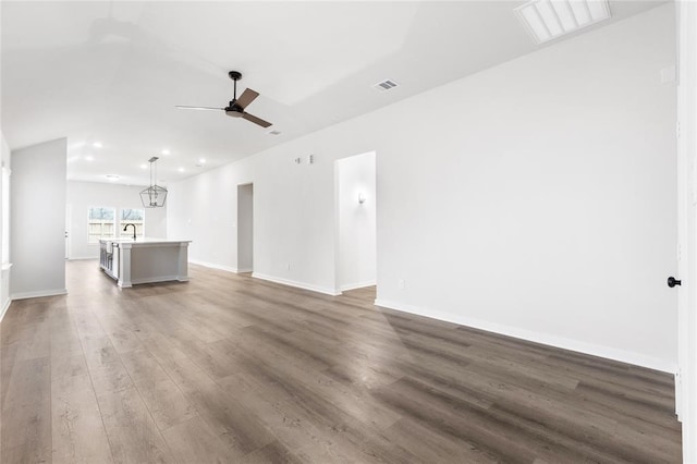 unfurnished living room with ceiling fan, baseboards, visible vents, and wood finished floors
