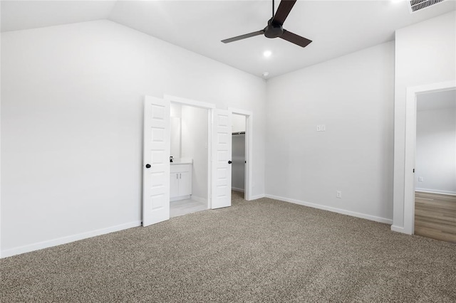 unfurnished bedroom featuring visible vents, a spacious closet, carpet flooring, and vaulted ceiling