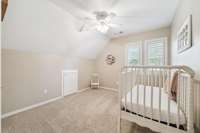bedroom with visible vents, baseboards, a textured ceiling, carpet flooring, and lofted ceiling