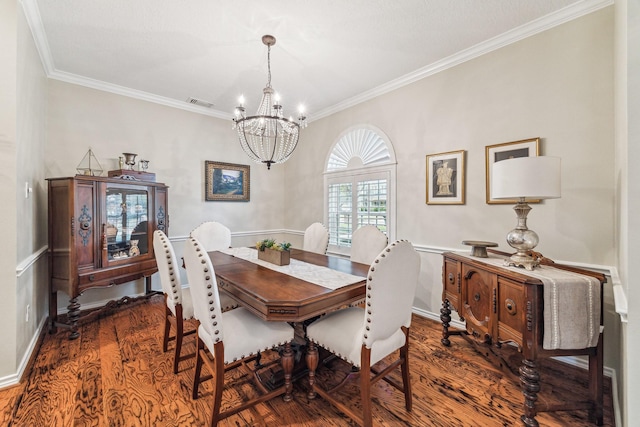 dining room with a notable chandelier, visible vents, ornamental molding, and wood finished floors