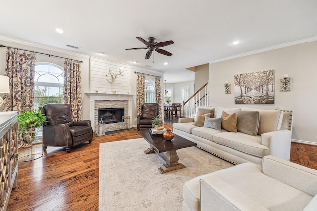 living area with crown molding, visible vents, a ceiling fan, and a healthy amount of sunlight
