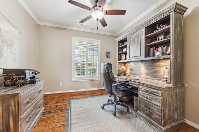 office featuring baseboards, ornamental molding, a ceiling fan, visible vents, and wood finished floors