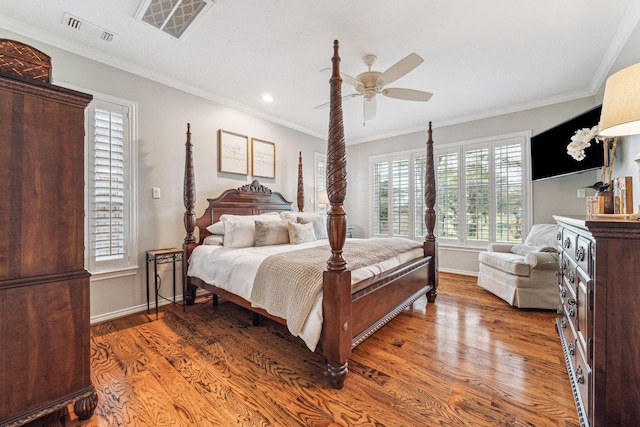 bedroom featuring crown molding, visible vents, baseboards, and wood finished floors