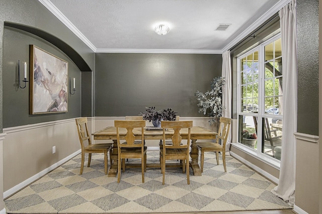 17939 Channel Hill Dr, Cypress, TX 77433 - dining space featuring arched walkways, visible vents, ornamental molding, and a wainscoted wall