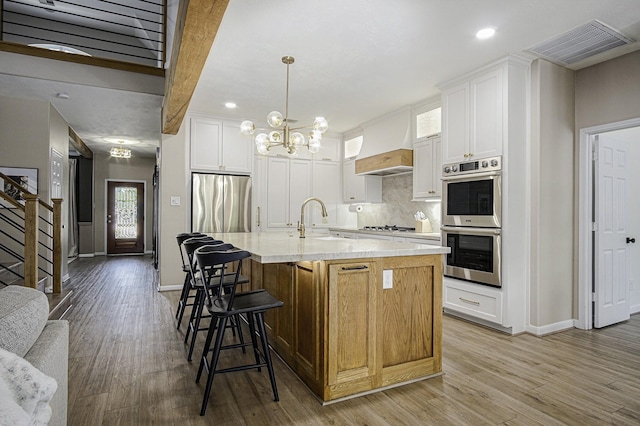 17939 Channel Hill Dr, Cypress, TX 77433 - kitchen with visible vents, custom exhaust hood, appliances with stainless steel finishes, a sink, and baseboards