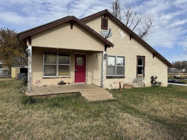 view of front of property featuring a front lawn and stucco siding