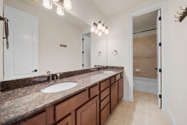 bathroom with a sink, tile patterned floors, double vanity, and baseboards
