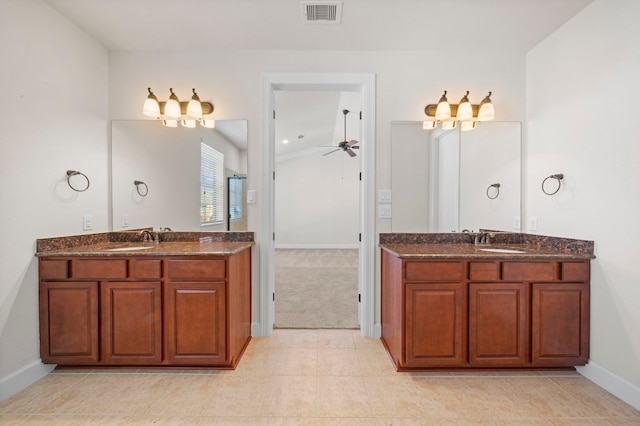 full bath with a sink, visible vents, baseboards, and two vanities