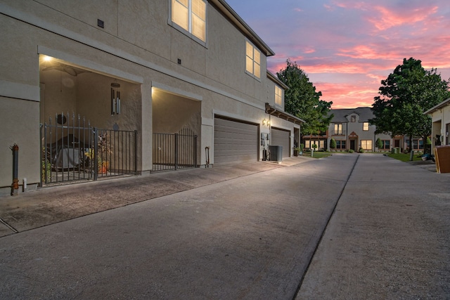 exterior space featuring a garage, stucco siding, and concrete driveway