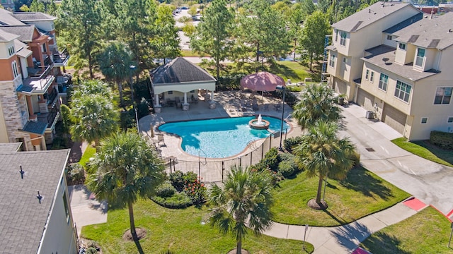 view of swimming pool with a patio area, a residential view, fence, and a yard