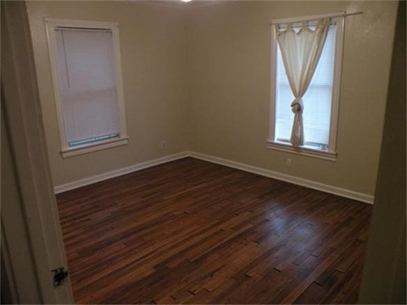 5600 Community Dr, Houston, TX 77005 - spare room featuring baseboards and dark wood finished floors