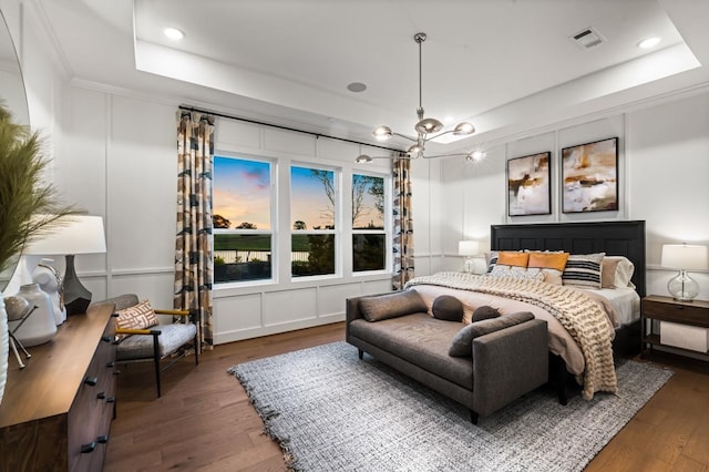 bedroom with wood-type flooring, recessed lighting, a raised ceiling, and visible vents