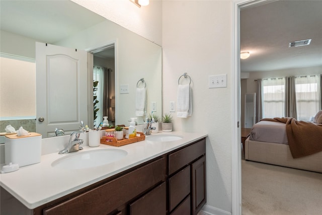 ensuite bathroom with visible vents, a sink, ensuite bath, and double vanity