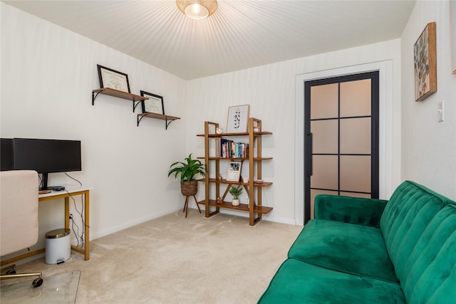 sitting room featuring baseboards and light carpet