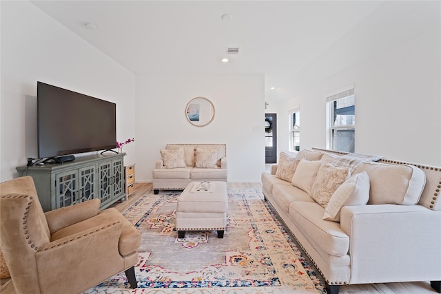 living area with recessed lighting, visible vents, baseboards, and wood finished floors