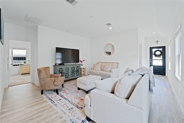 living room with a healthy amount of sunlight, visible vents, and light wood-style flooring