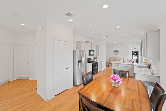 dining area with light wood-style floors, visible vents, and recessed lighting