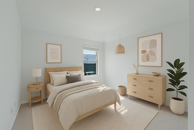 bedroom featuring light colored carpet and baseboards