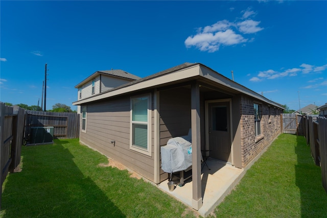 rear view of house with a yard, a patio, and a fenced backyard