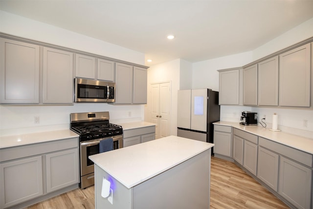 4411 Aspen Colony Ln, Baytown, TX 77521 - kitchen featuring stainless steel appliances, light countertops, gray cabinets, a center island, and light wood-style flooring