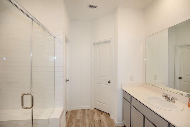 4411 Aspen Colony Ln, Baytown, TX 77521 - full bath with wood finished floors, visible vents, vanity, and a stall shower