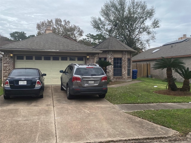 view of front of house with a shingled roof, a front lawn, concrete driveway, an attached garage, and brick siding