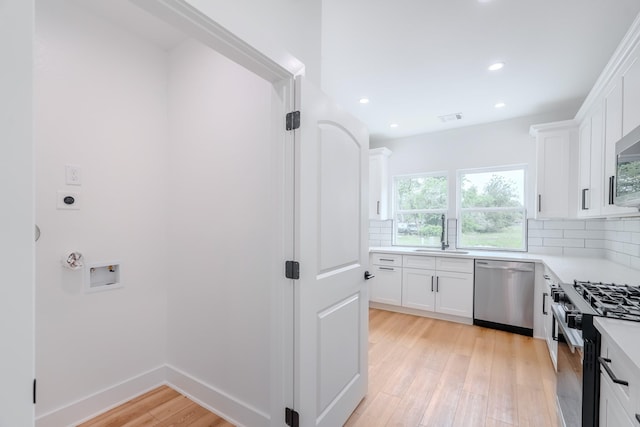 interior space with light wood-style flooring, a sink, hookup for an electric dryer, visible vents, and recessed lighting