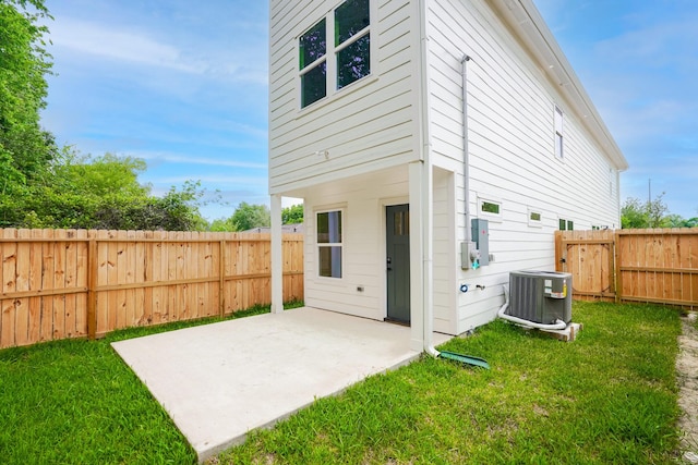 back of property featuring a patio area, a fenced backyard, a yard, and central air condition unit