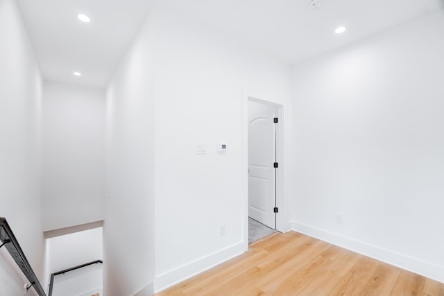 hall featuring recessed lighting, light wood finished floors, baseboards, and an upstairs landing