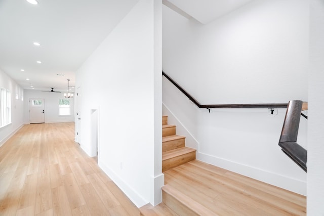 staircase with baseboards, wood finished floors, and recessed lighting