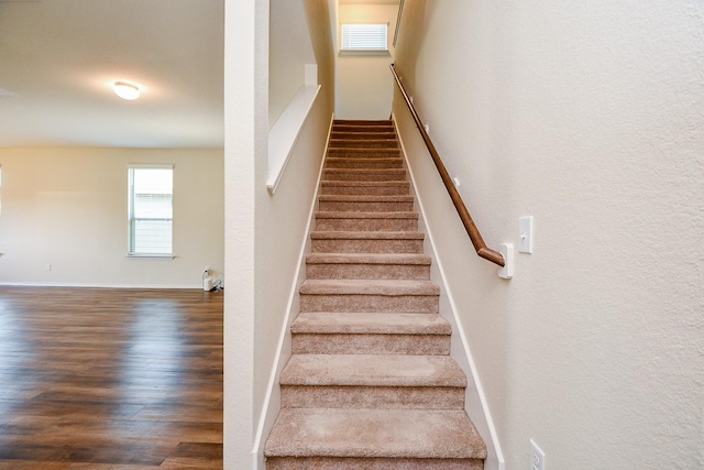 stairway with wood finished floors and baseboards