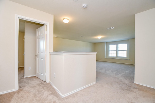 hall featuring an upstairs landing, carpet flooring, baseboards, and visible vents